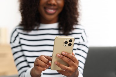 Beautiful woman using mobile phone at home, closeup