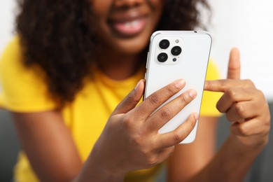 Photo of Beautiful woman using mobile phone at home, closeup