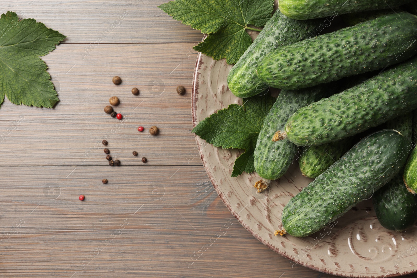 Photo of Fresh green cucumbers and spices on wooden table, flat lay. Space for text