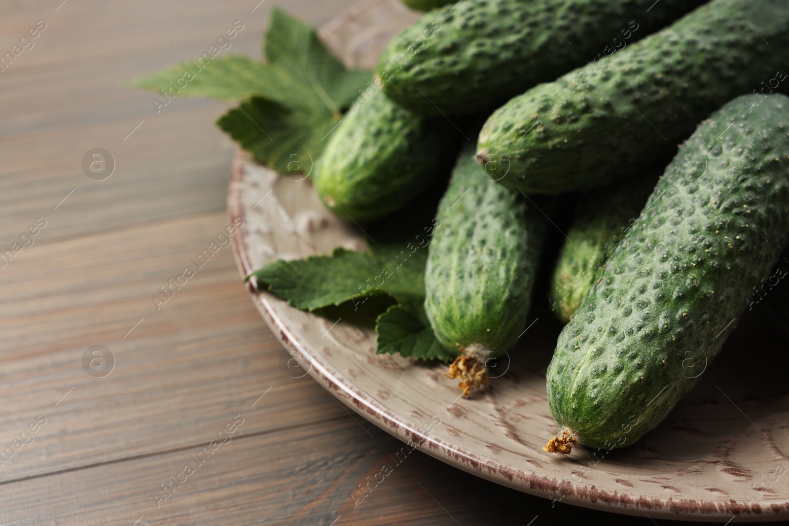 Photo of Fresh green cucumbers on wooden table, closeup