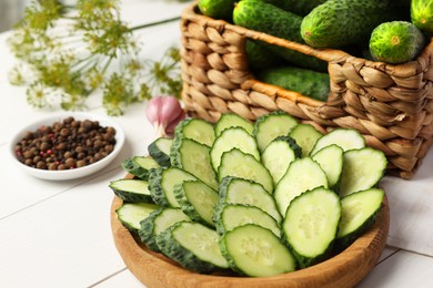 Photo of Fresh green cucumbers and spices on white wooden table