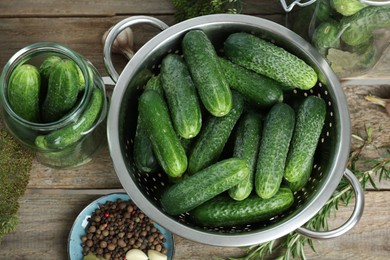 Photo of Fresh cucumbers, herbs and spices on wooden table, flat lay. Preparation for pickling