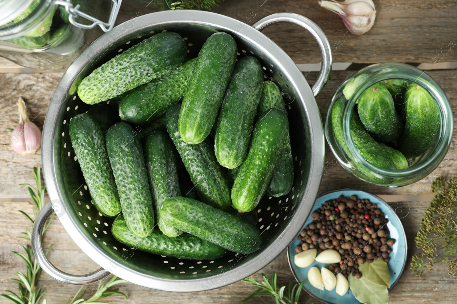 Photo of Fresh cucumbers, herbs and spices on wooden table, flat lay. Preparation for pickling