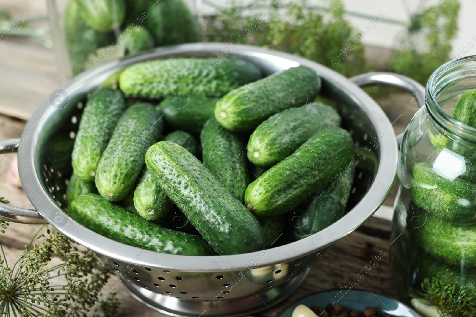 Photo of Fresh cucumbers and dill on wooden table, closeup. Preparation for pickling