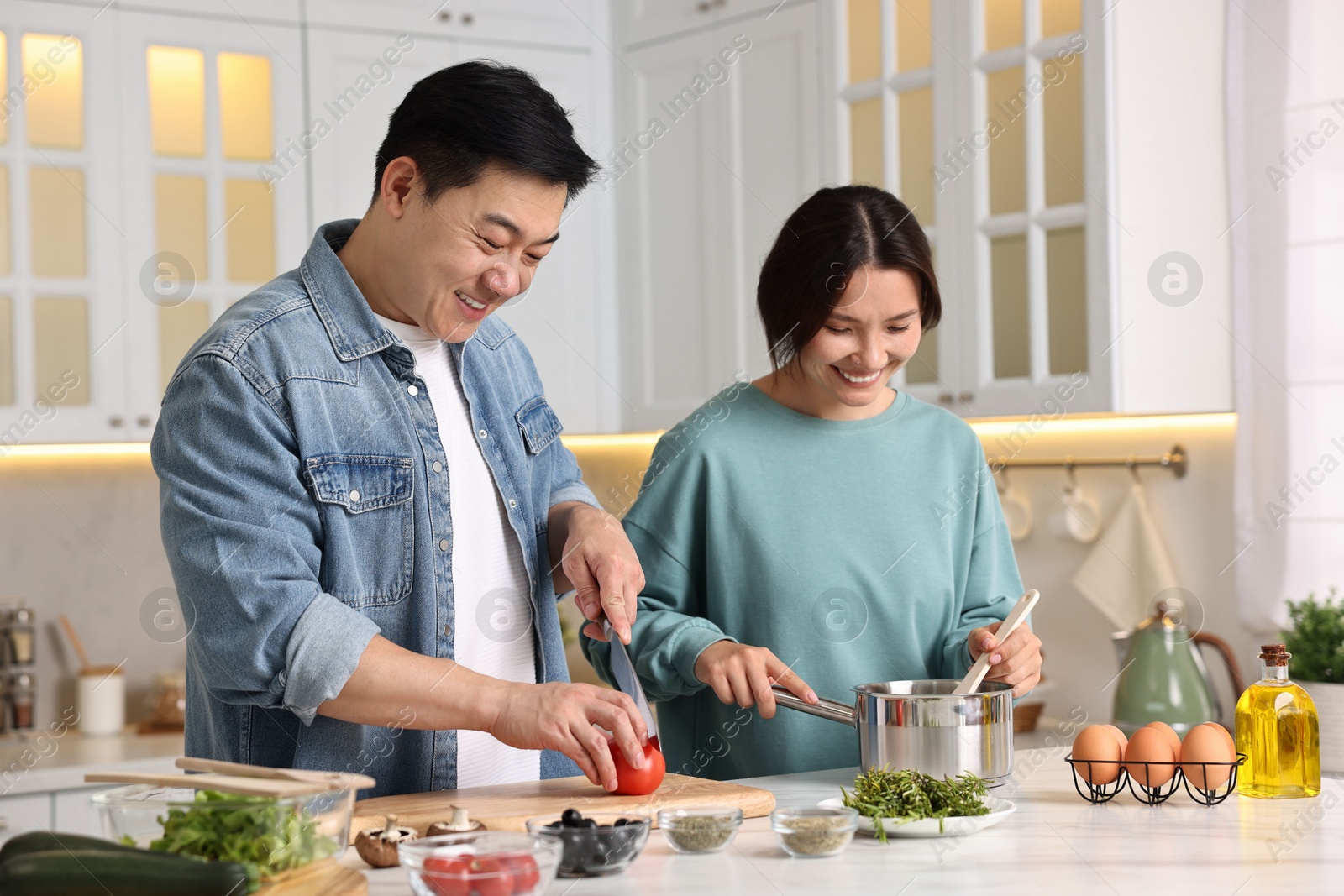 Photo of Happy lovely couple cooking together in kitchen