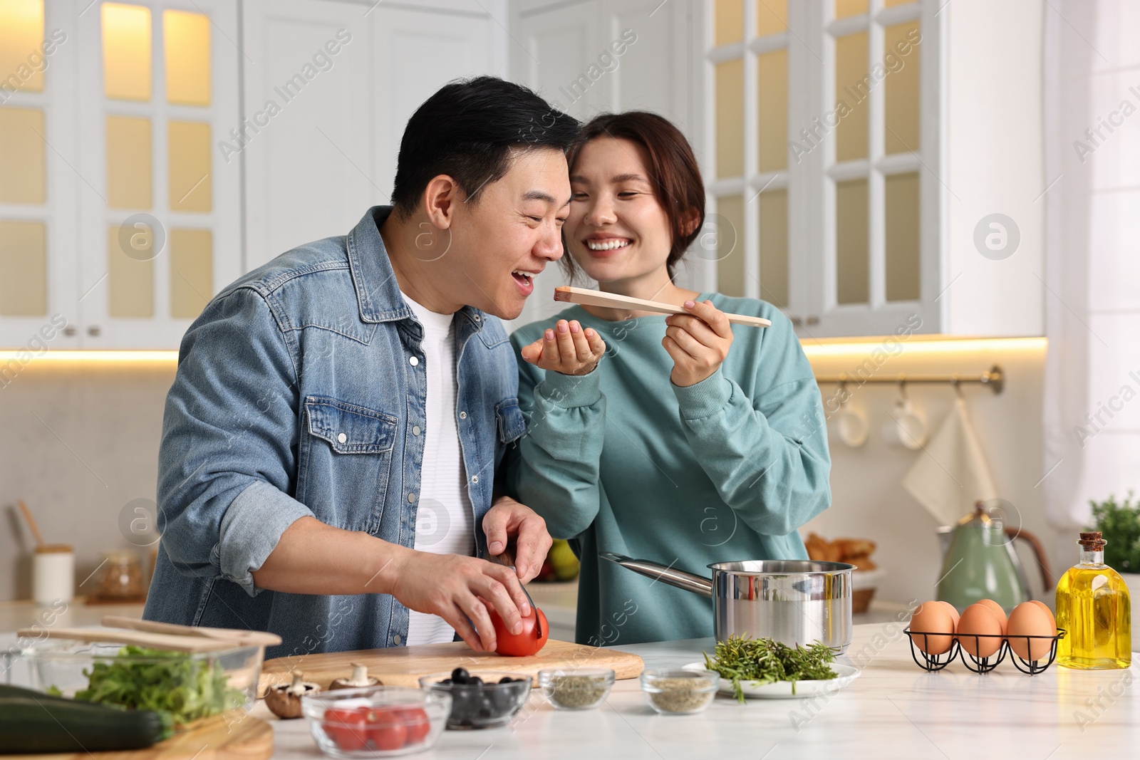 Photo of Happy lovely couple cooking together in kitchen