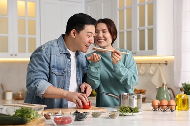 Photo of Happy lovely couple cooking together in kitchen