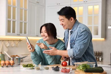 Photo of Happy lovely couple cooking together in kitchen