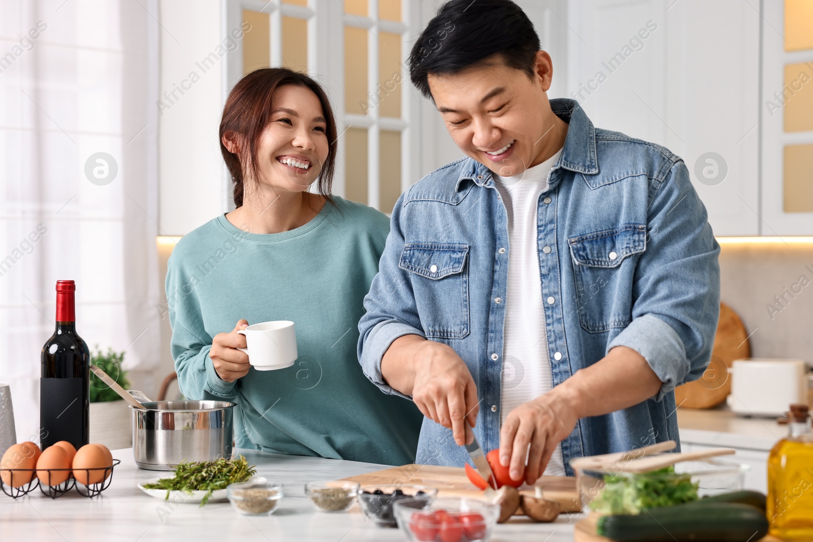 Photo of Happy lovely couple cooking together in kitchen