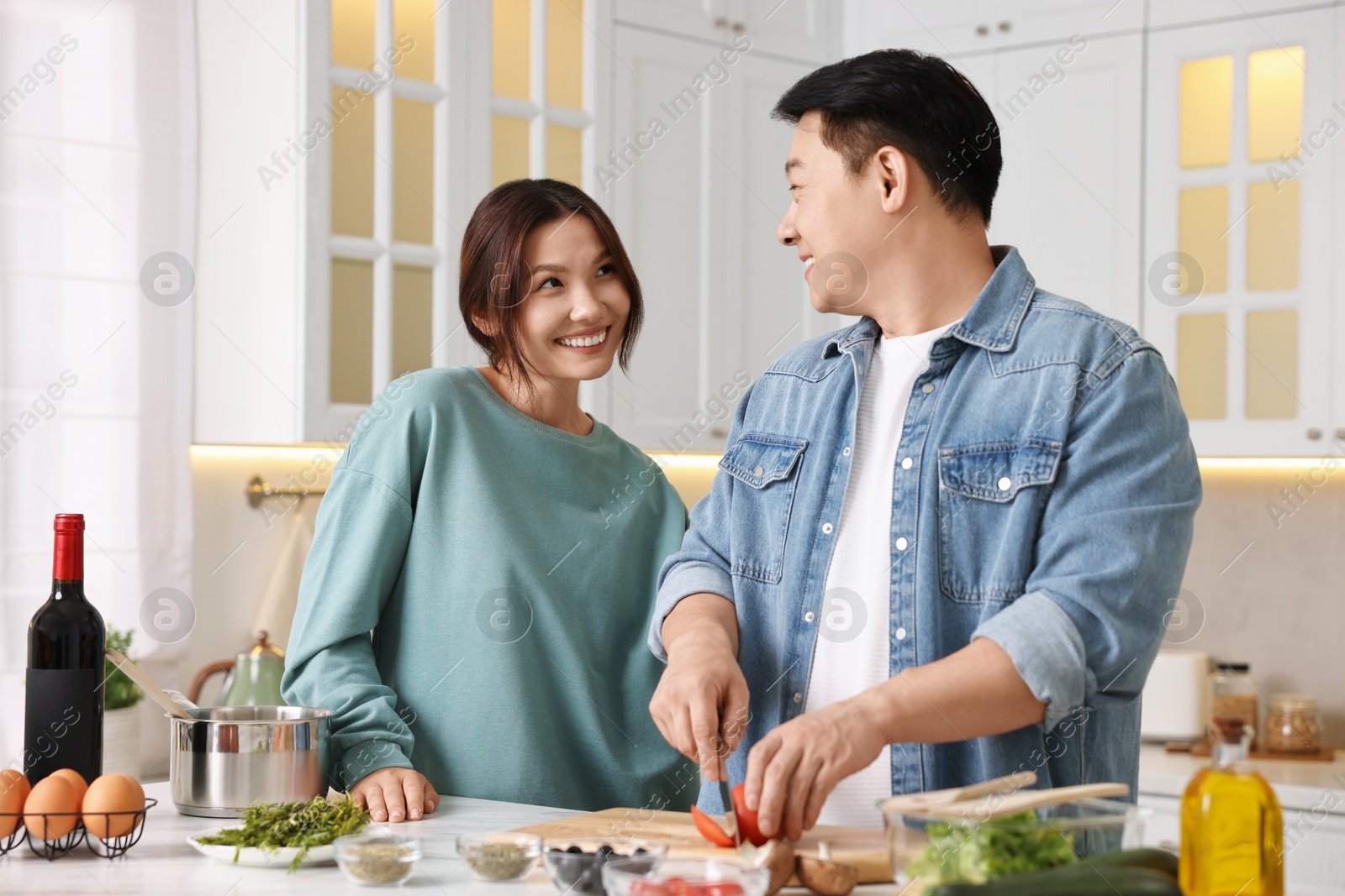 Photo of Happy lovely couple cooking together in kitchen