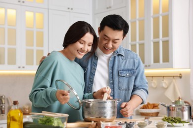 Photo of Happy lovely couple cooking together in kitchen