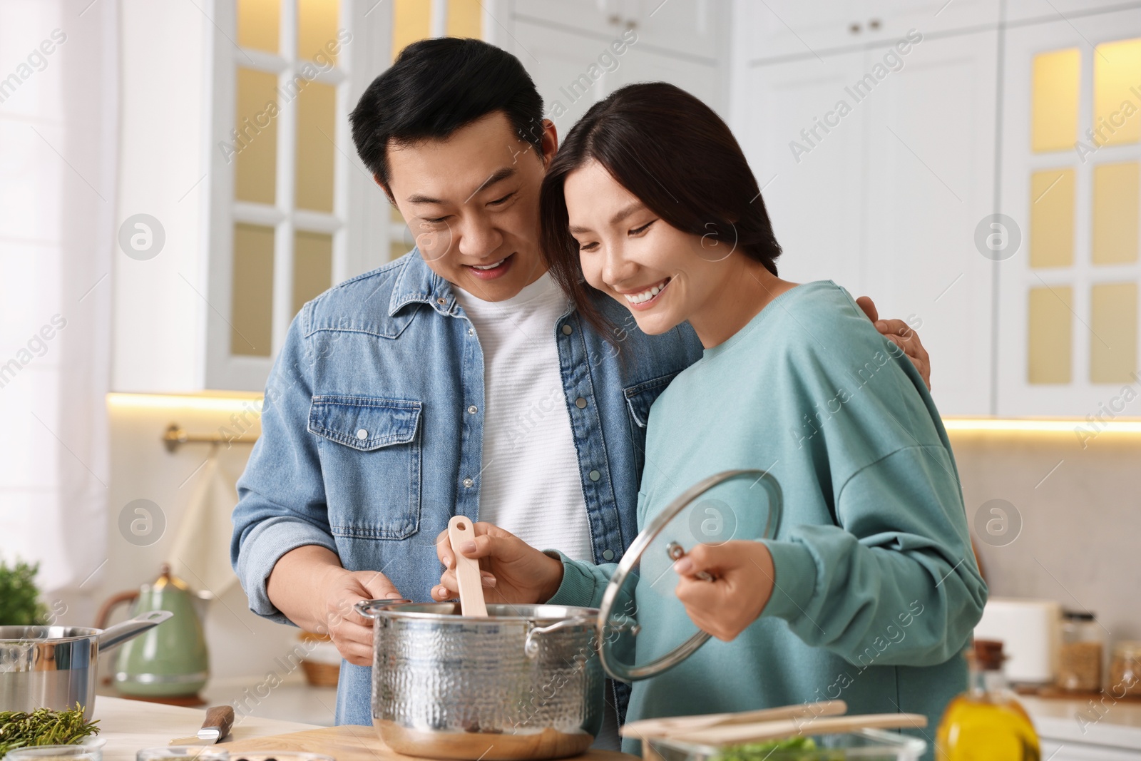 Photo of Happy lovely couple cooking together in kitchen