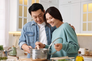 Photo of Happy lovely couple cooking together in kitchen