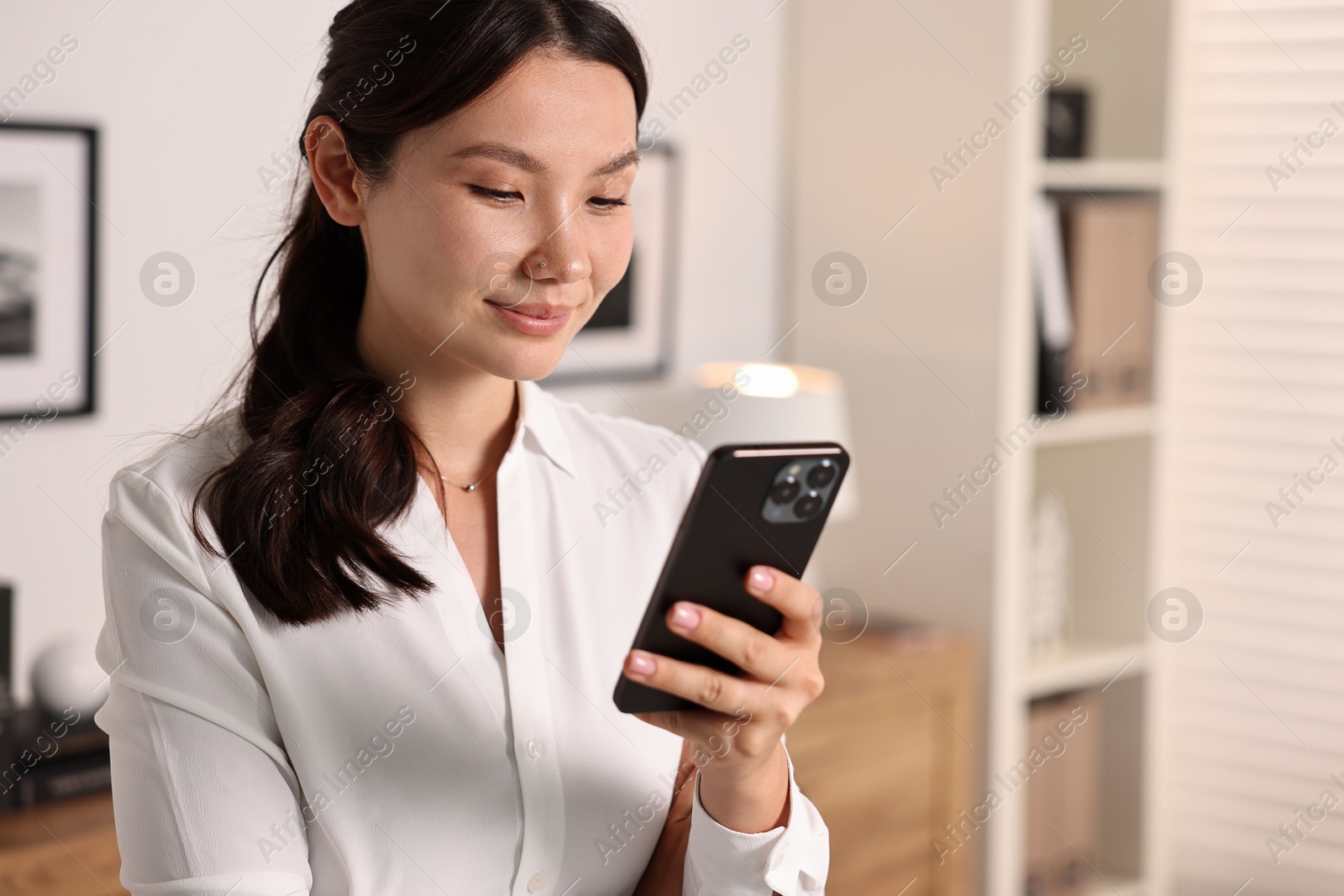 Photo of Beautiful businesswoman with smartphone in office. Space for text