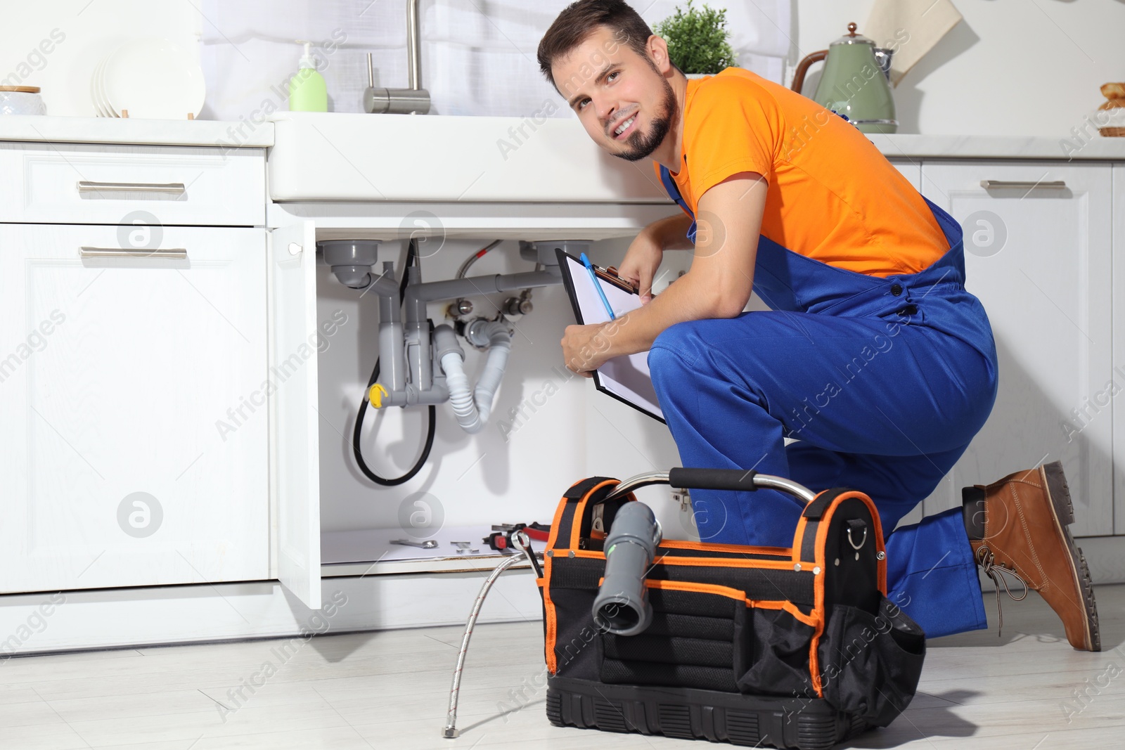 Photo of Professional plumber fixing piping system at home