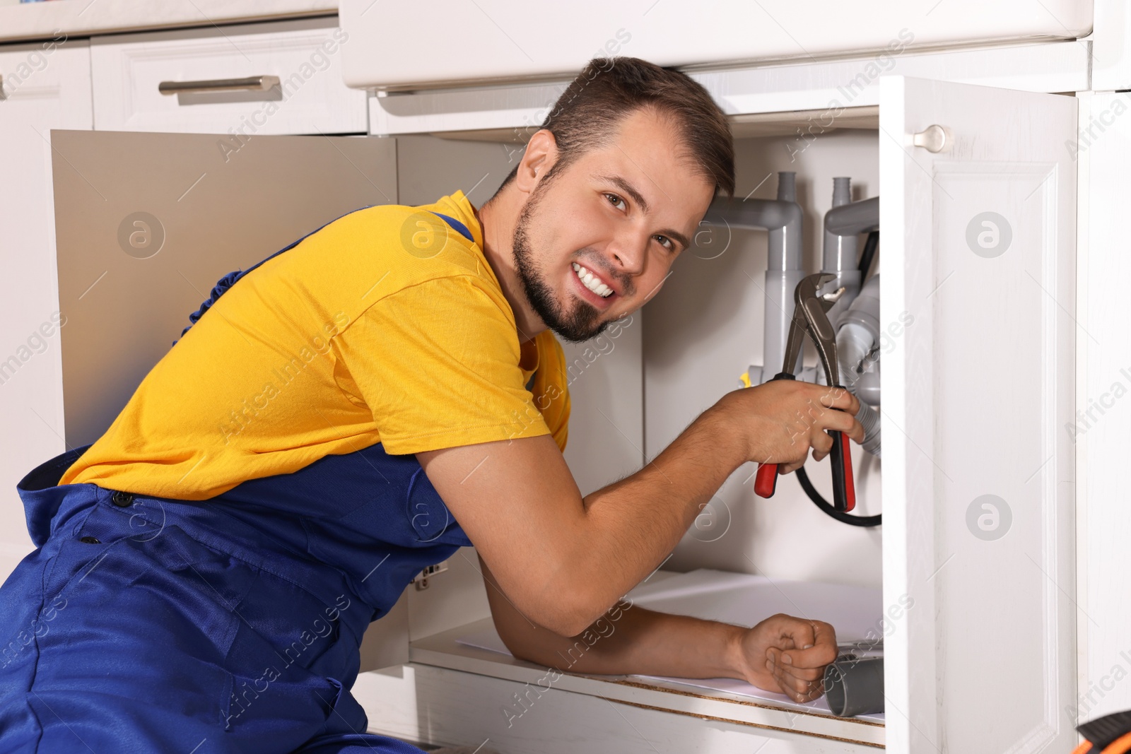 Photo of Professional plumber fixing piping system at home