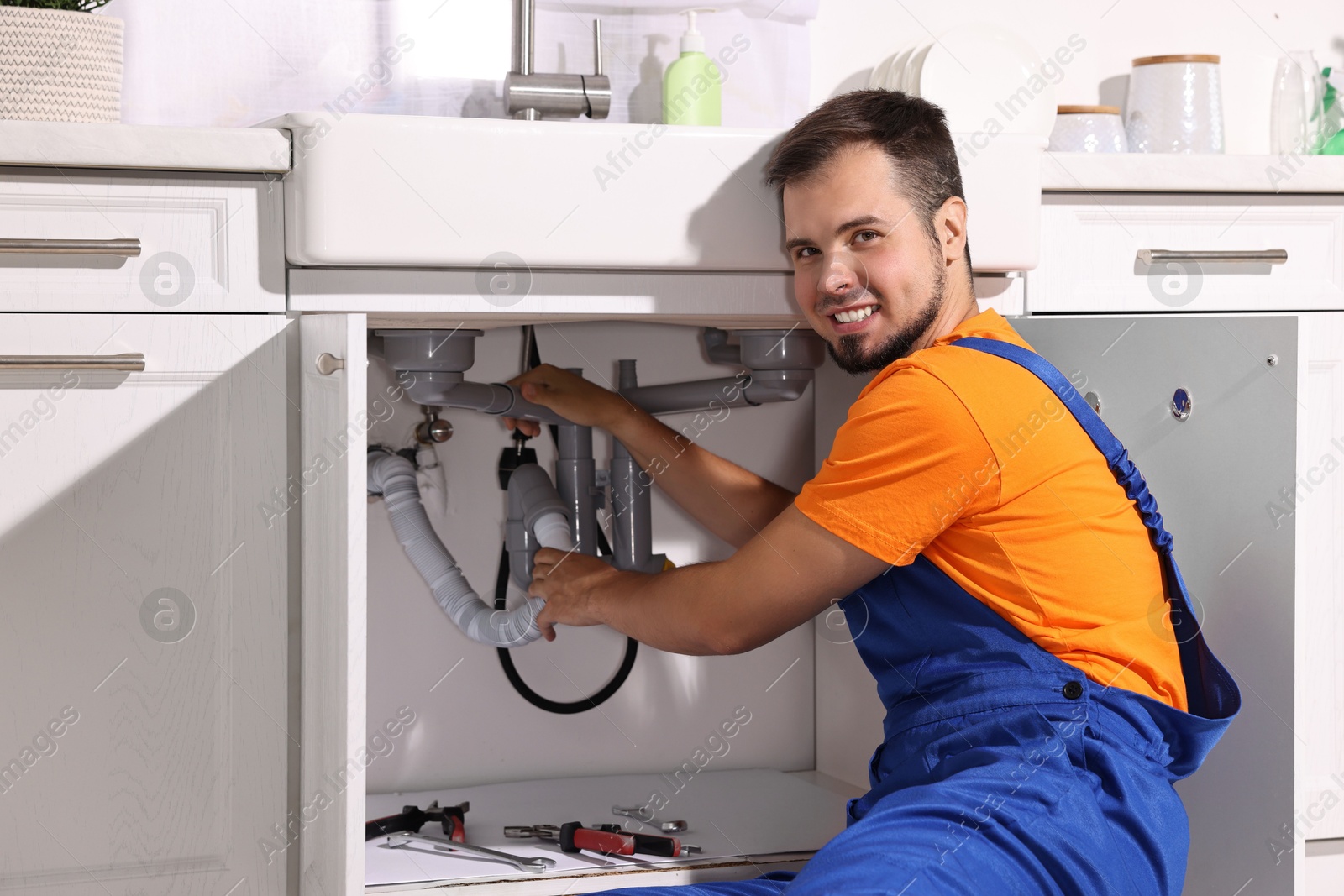 Photo of Professional plumber fixing piping system at home