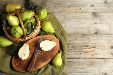 Photo of Fresh green pears, knife and napkin on wooden table, flat lay. Space for text