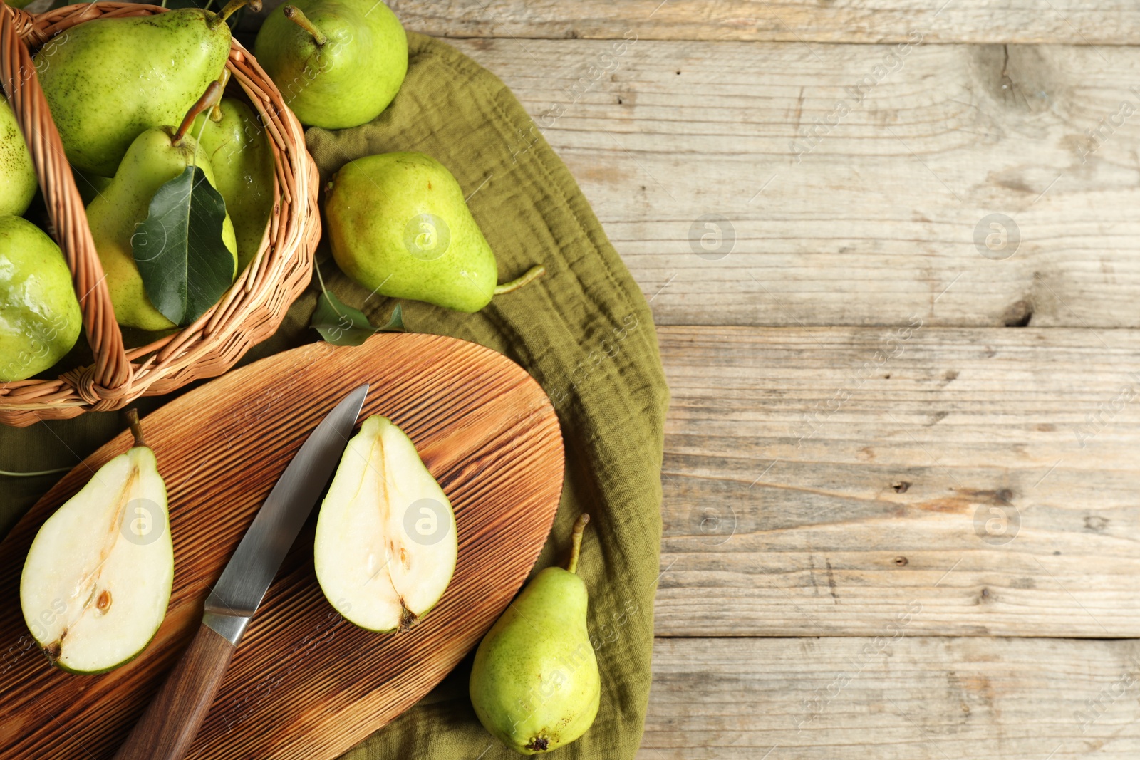 Photo of Fresh green pears, knife and napkin on wooden table, flat lay. Space for text