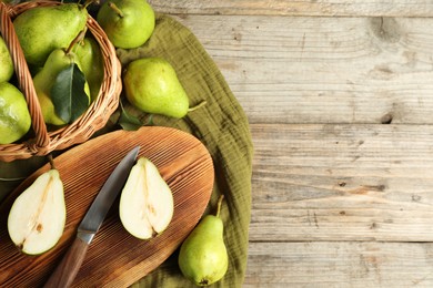 Photo of Fresh green pears, knife and napkin on wooden table, flat lay. Space for text