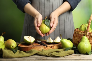 Photo of Woman with fresh green pears at wooden table, closeup