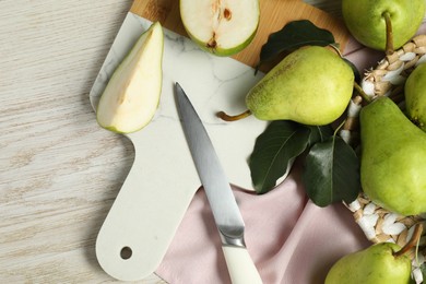 Photo of Fresh green pears with leaves and knife on light wooden table