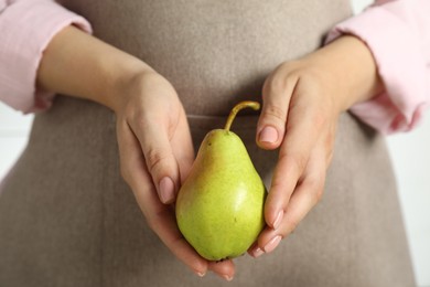 Photo of Woman with fresh green pear on white background, closeup