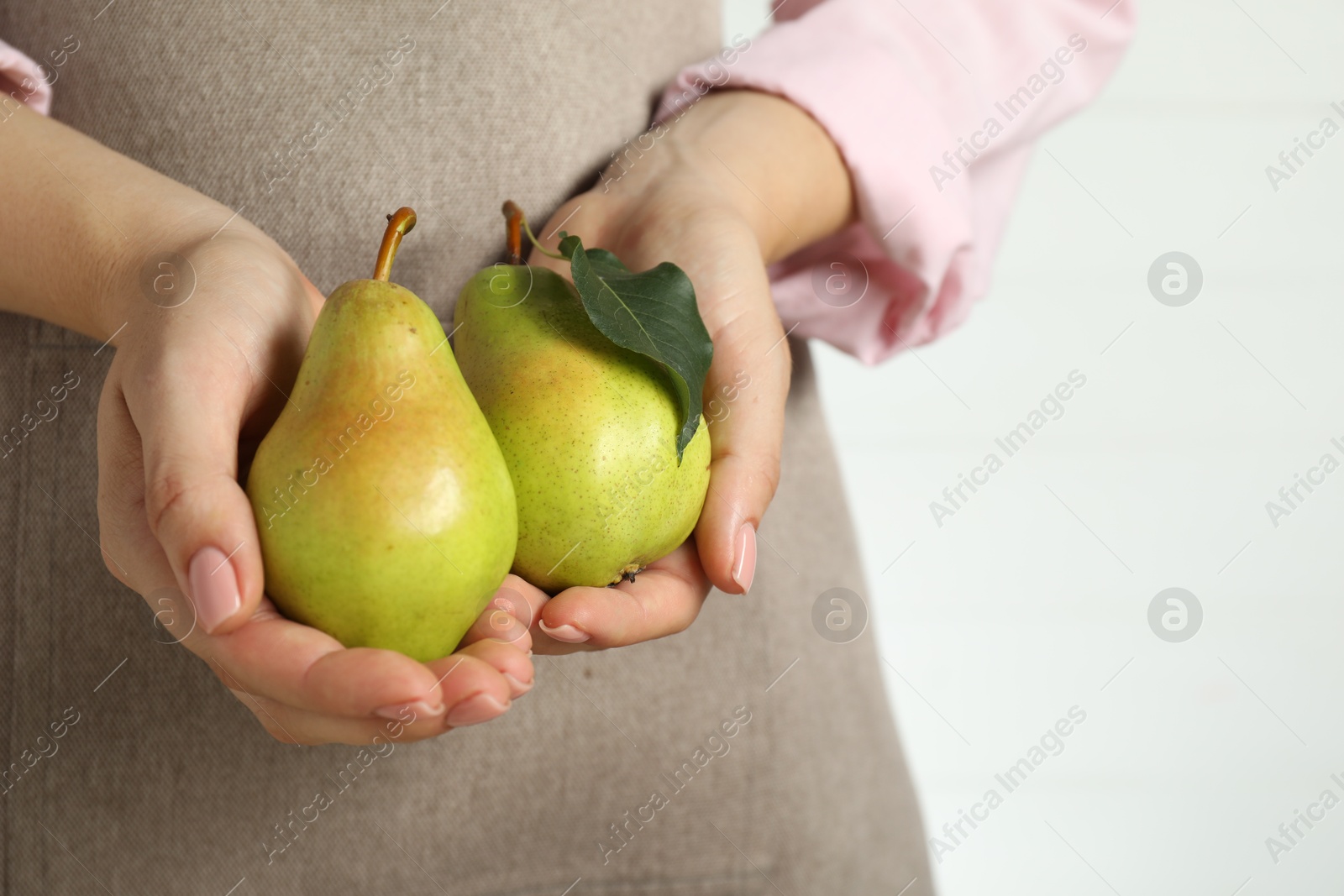 Photo of Woman with fresh green pears on white background, closeup. Space for text