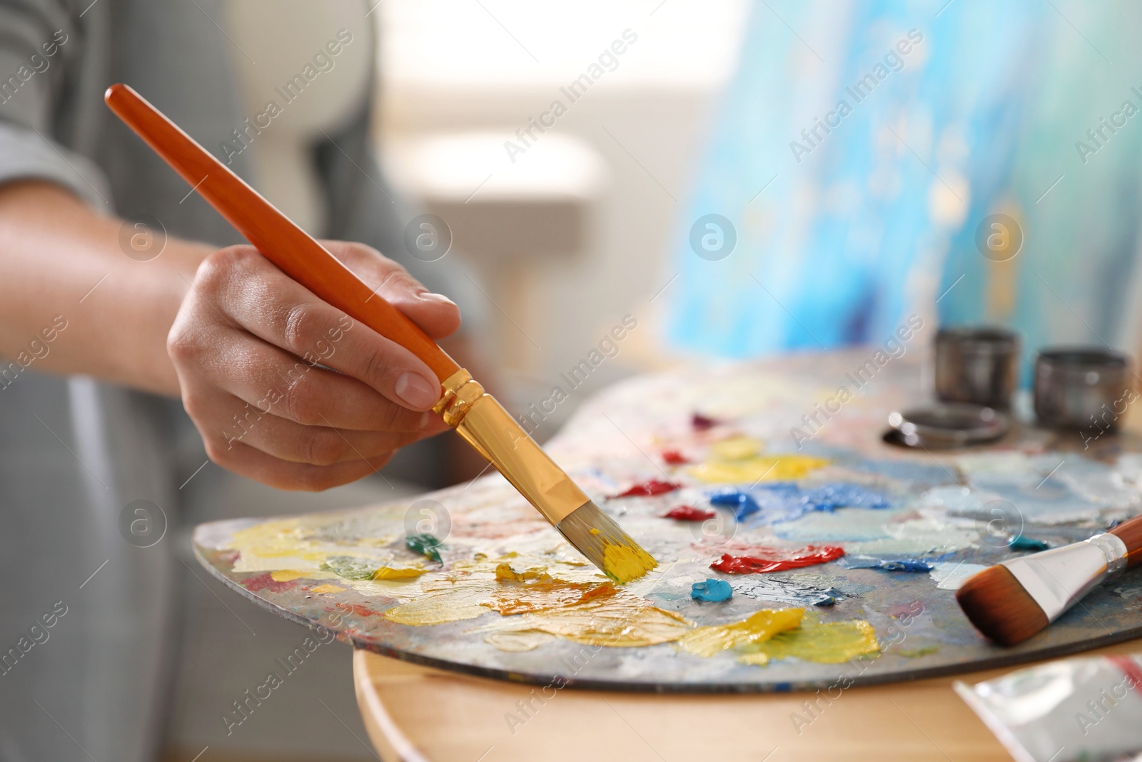 Photo of Woman with brush using palette at table indoors, closeup