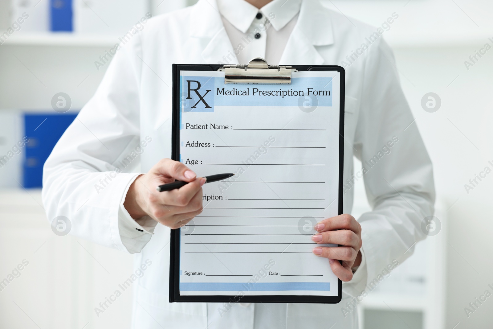 Photo of Doctor with blank prescription form in clinic, closeup