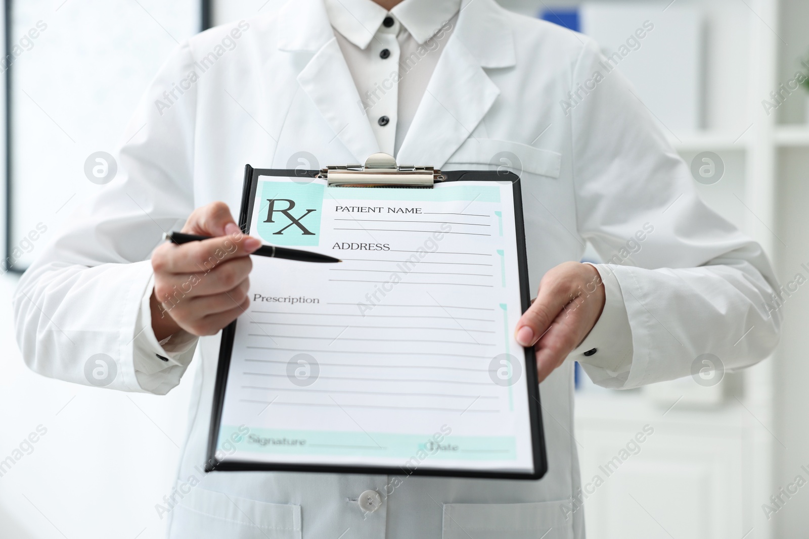 Photo of Doctor with blank prescription form in clinic, closeup