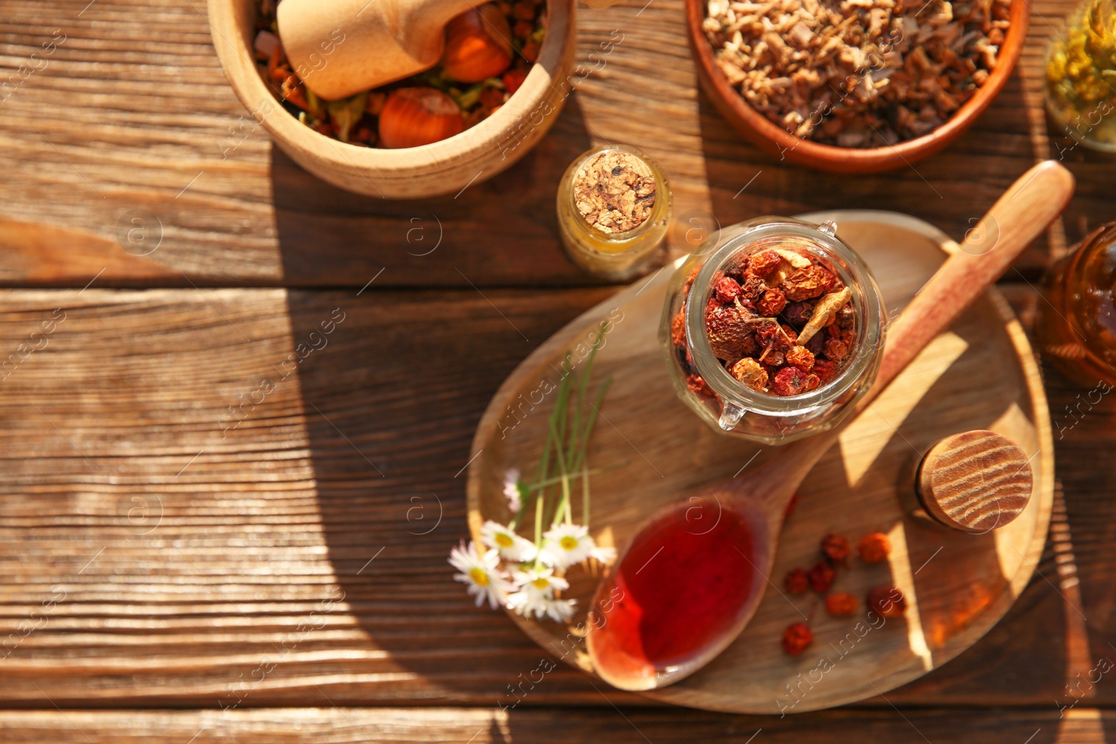 Photo of Tincture, different ingredients, mortar and pestle on wooden table, top view. Space for text