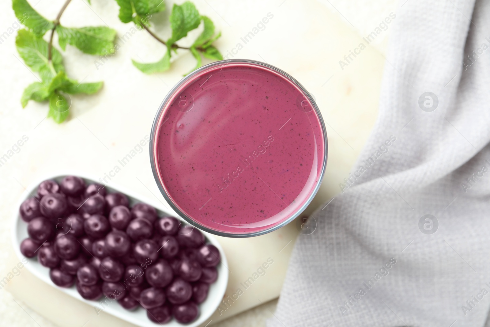 Photo of Tasty fresh acai juice in glass on light table, top view