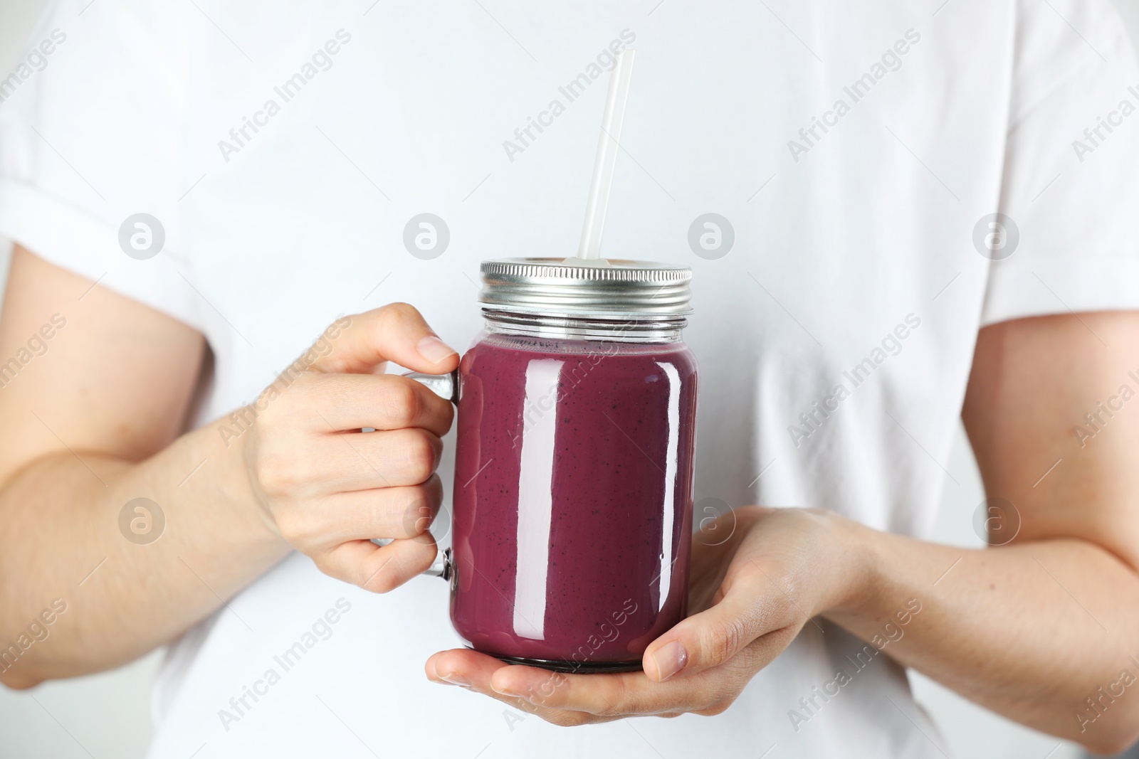 Photo of Woman with mason jar of tasty fresh acai juice, closeup