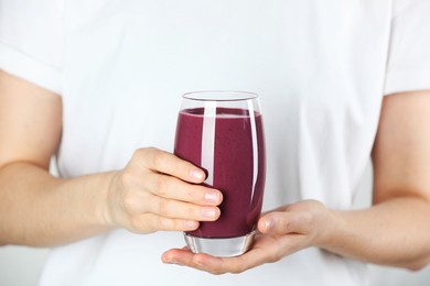 Photo of Woman with glass of tasty fresh acai juice, closeup