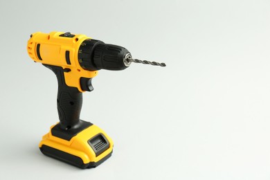 Photo of Modern cordless electric drill on white background. Space for text