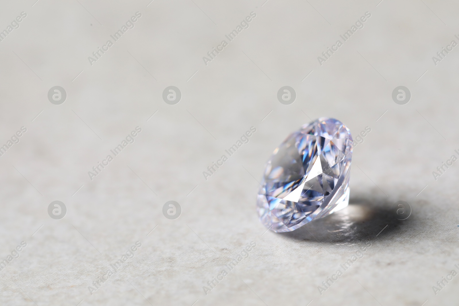 Photo of One beautiful shiny diamond on light background, closeup. Space for text