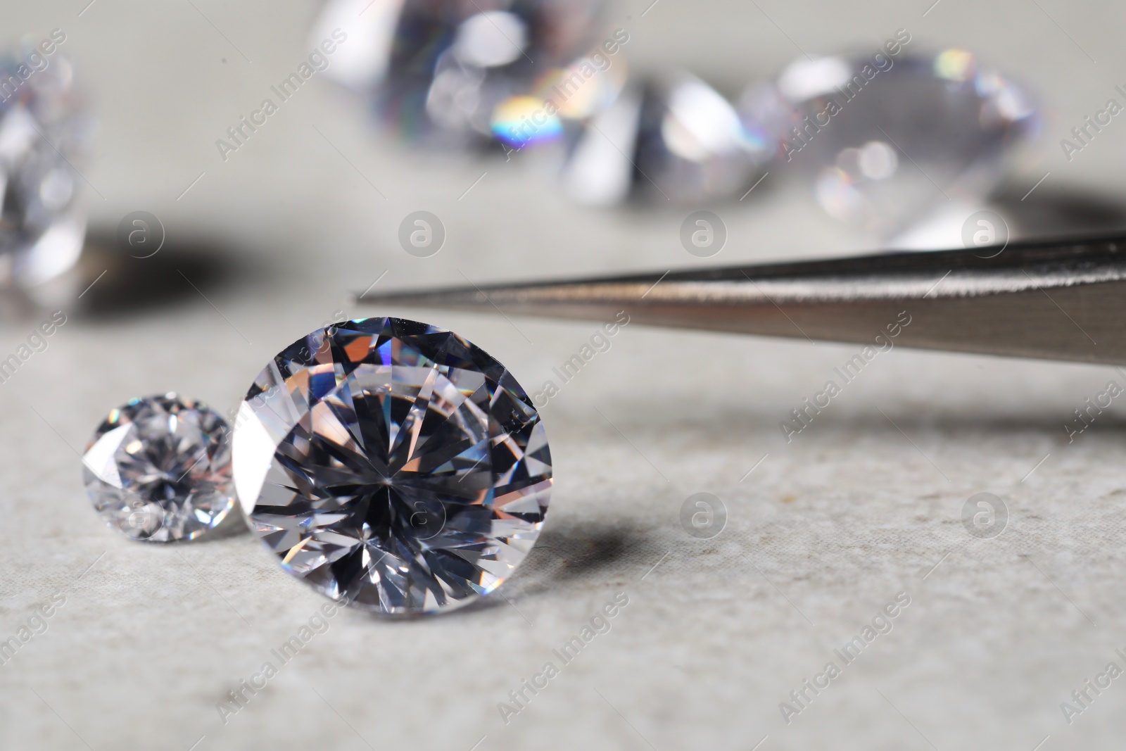 Photo of Many beautiful shiny diamonds on light background, closeup