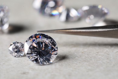 Photo of Many beautiful shiny diamonds on light background, closeup