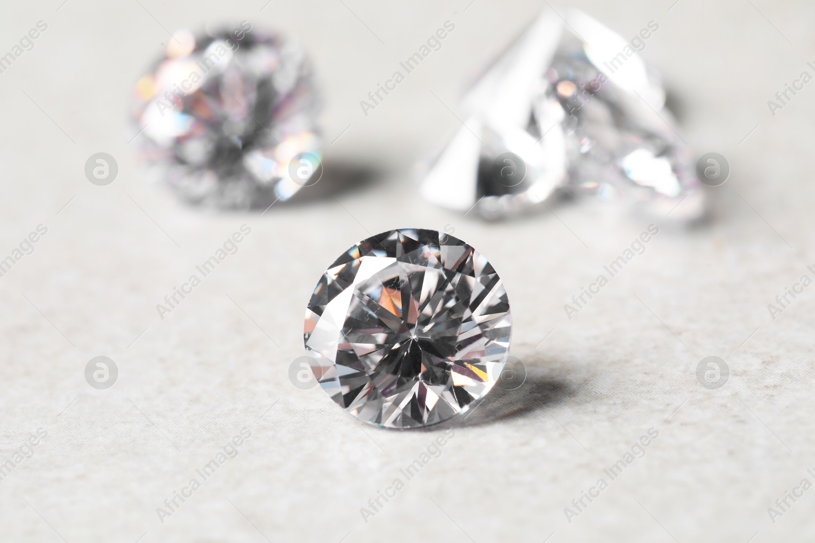 Photo of Many beautiful shiny diamonds on light background, closeup