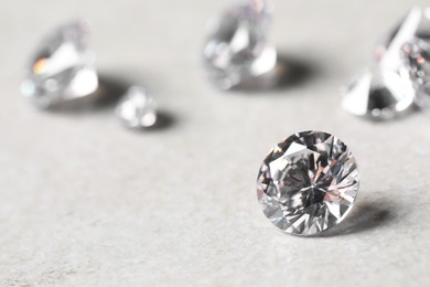 Photo of Many beautiful shiny diamonds on light background, closeup. Space for text