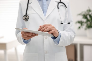 Photo of Doctor using tablet in hospital, closeup view