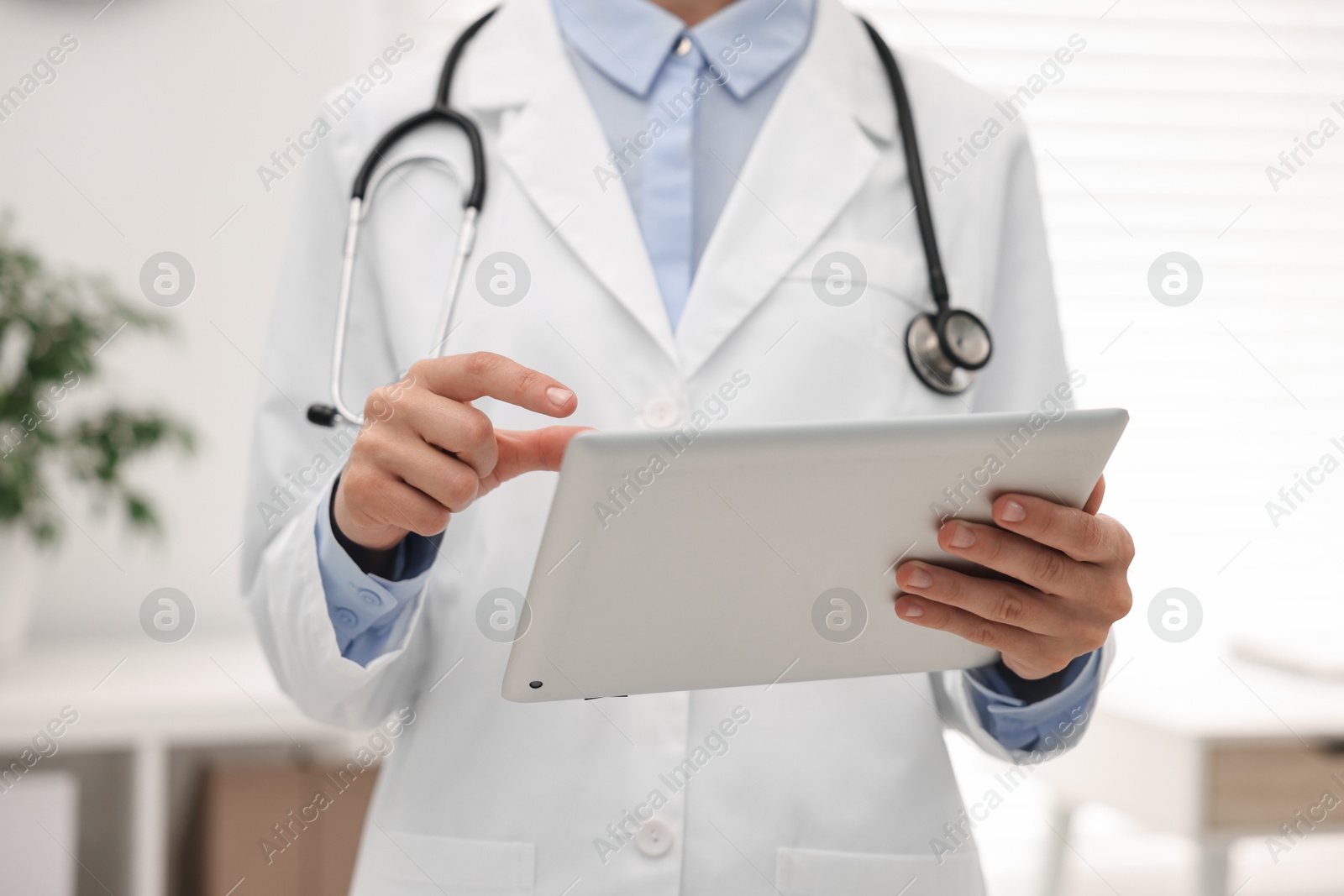 Photo of Doctor using tablet in hospital, closeup view