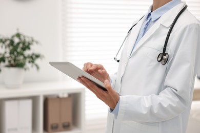 Photo of Doctor using tablet in hospital, closeup view