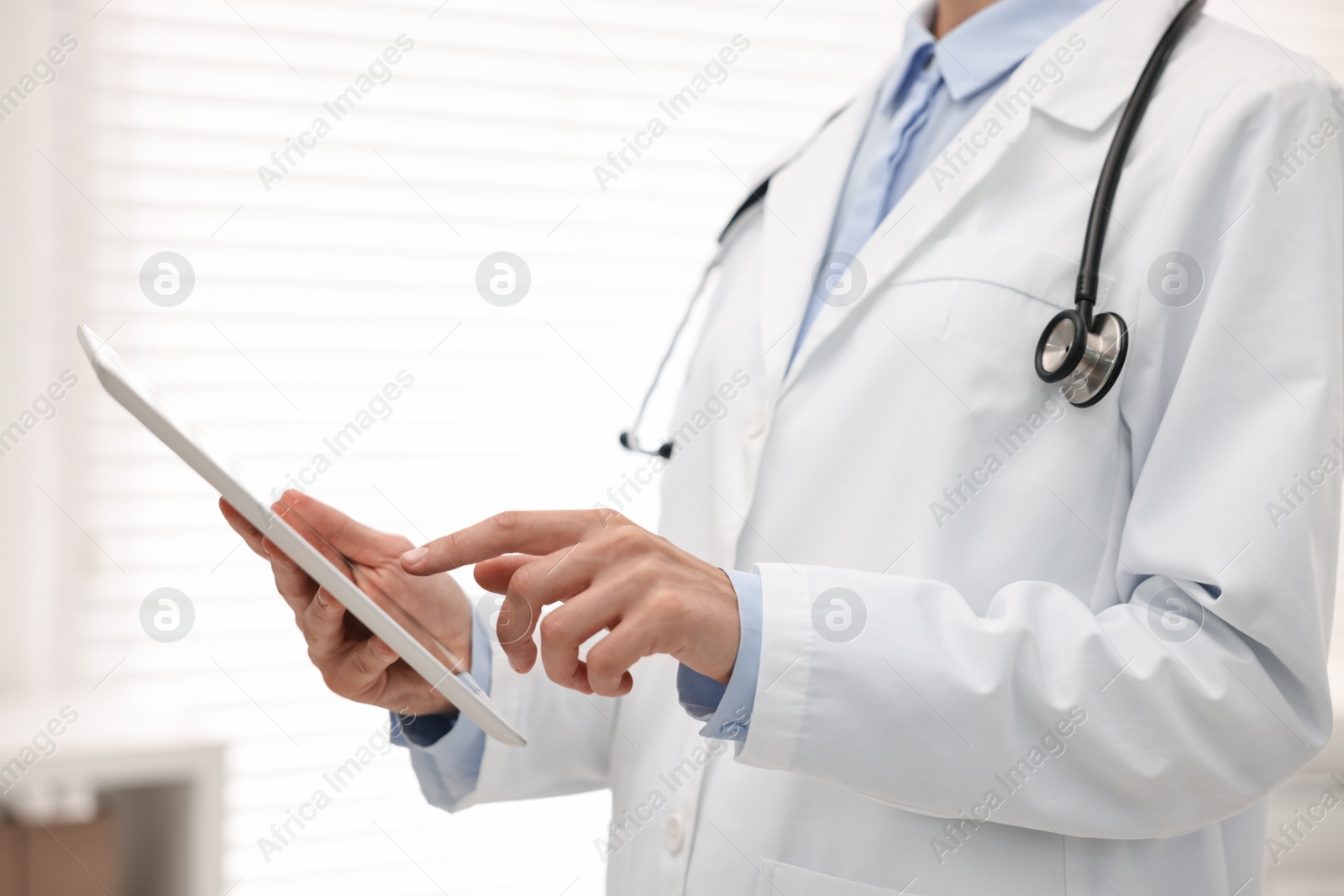 Photo of Doctor using tablet in hospital, closeup view