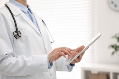 Photo of Doctor using tablet in hospital, closeup view