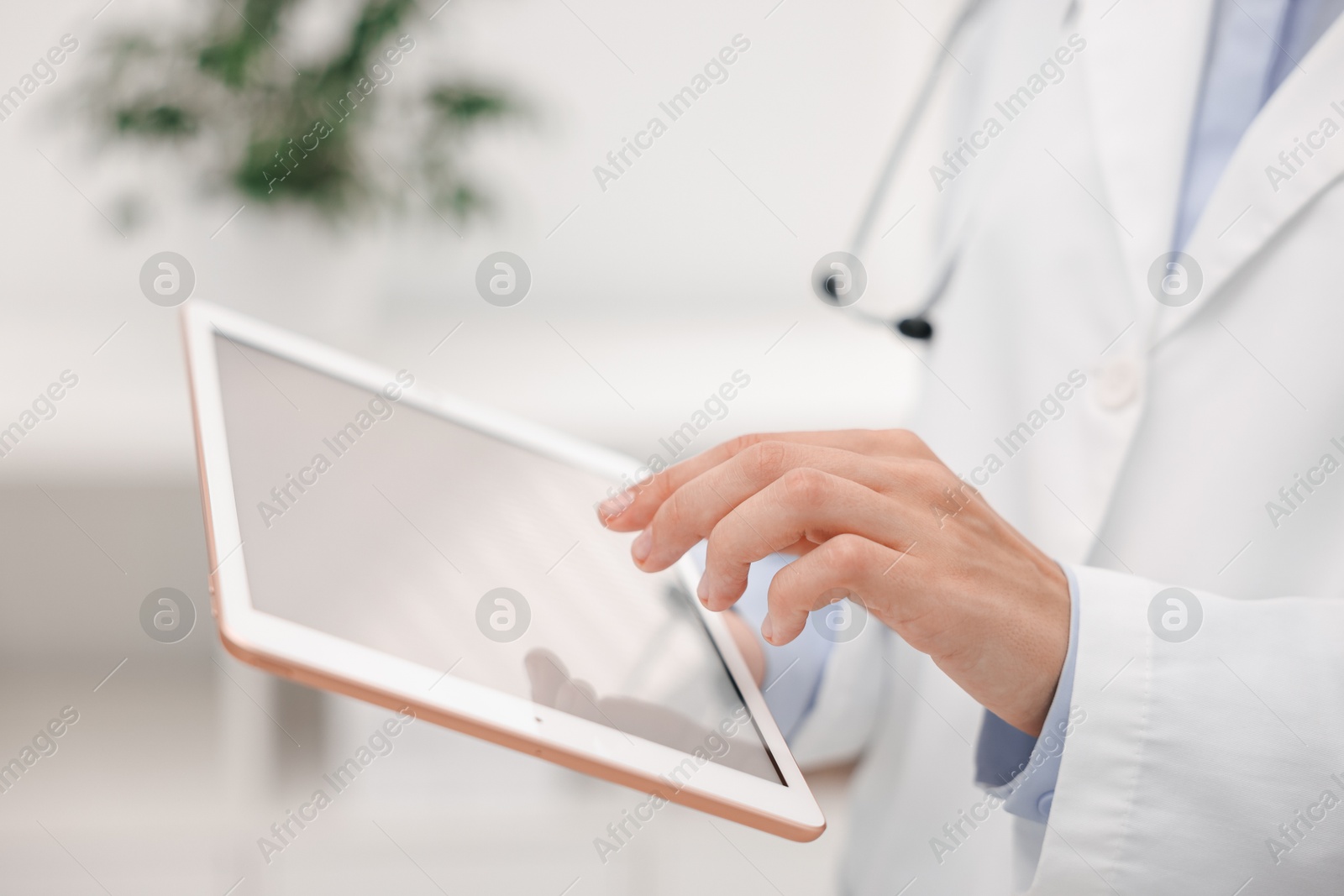 Photo of Doctor using tablet in hospital, closeup view