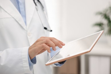 Photo of Doctor using tablet in hospital, closeup view