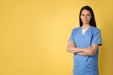 Portrait of beautiful nurse on yellow background. Space for text