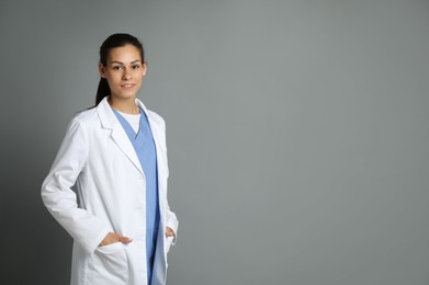 Photo of Portrait of smiling nurse on grey background. Space for text